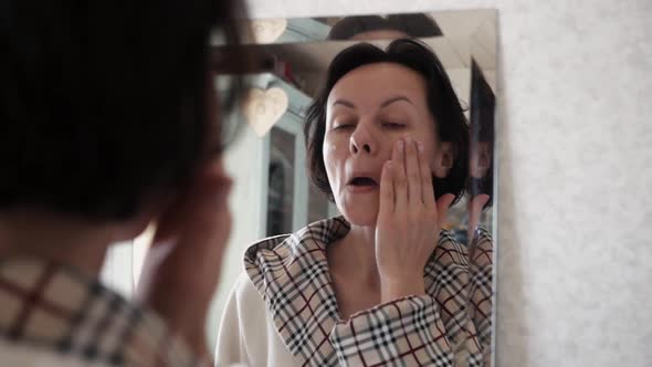 Portrait Of Beautiful Healthy Woman Putting Moisturizing Cream On Face.