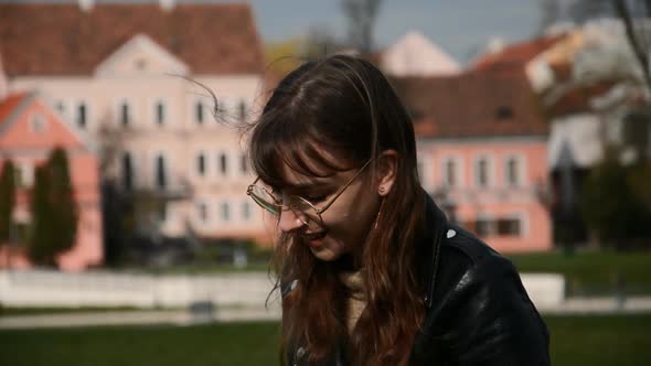 Young Caucasian Woman Wearing Glasses and Smiling at the Camera on the Urban City Street