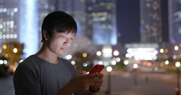 Asian man use of mobile phone in city at night