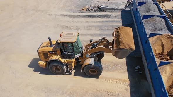 Excavator on the territory of asphalt manufacture outdoors. Modern excavator pouring out