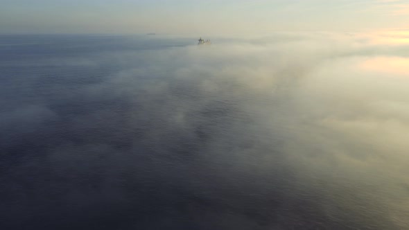 Aerial shot of  sea in foggy day with cargo ships