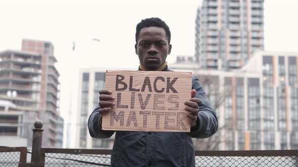 Young Man Holding Carton Placard with Black Lives Matter Writing