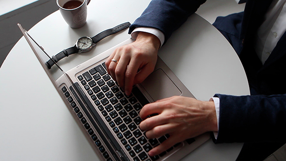 Man Working On Laptop And Drinking Coffee