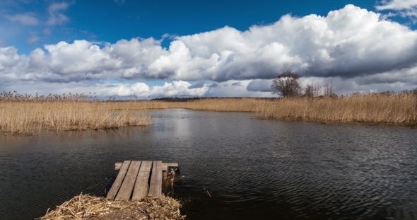 Lake With Pier And Clouds