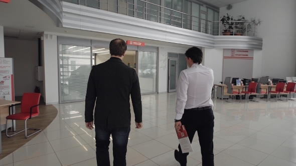 Car Dealer Showing Vehicle To Male Elegant Client