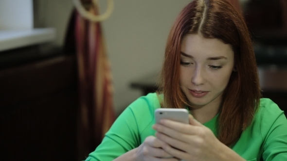 Women Takes In Hands The Smartphone And Texting On Mobile Phone, Smiling.