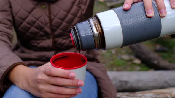 a Woman Pours Hot Delicious Tea From a Thermos