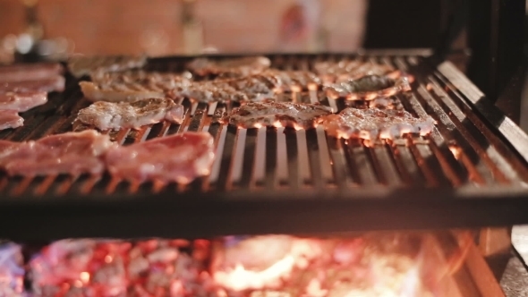 Cook Prepares Steaks On The Grill