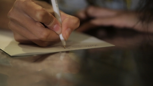 Woman's Hand With a Nice Manicure Natural Writing On Sheets Line By Line.