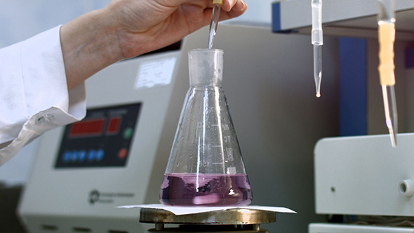 Scientist Examining Sample and Mix Liquid in Flask