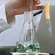 Researcher Examining Sample and Mix Green Liquid in Flask - VideoHive Item for Sale