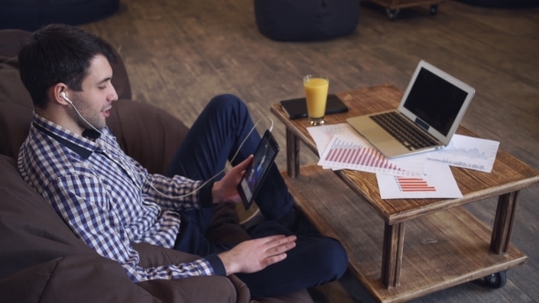 Attractive Man Holding Tablet In Hand, Headphones Dressed, Online Conference.