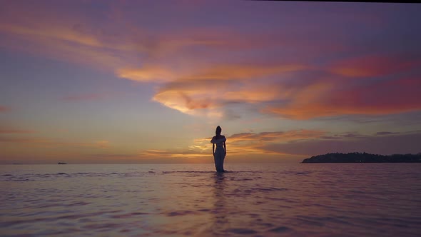 Woman Silhouette Walking Alone in the Sea at Beautiful Sunset Thailand