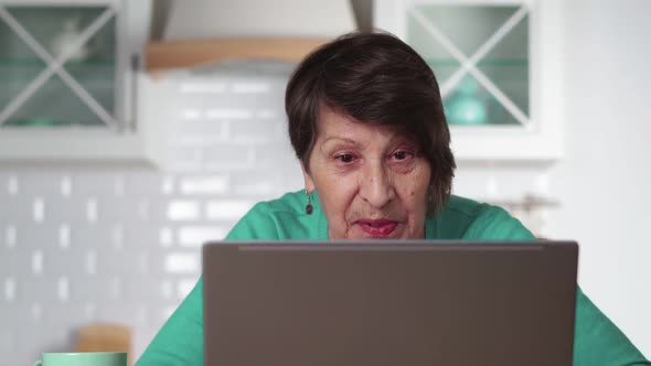 Adult Elderly Woman Communicates Via Video Communication with Her Relatives