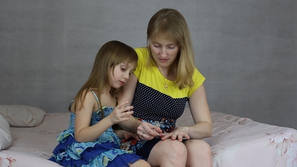 The Girl Helps her Mother to Paint her Nails Nail Polish