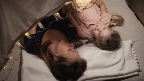 Happy Mom Enjoying Family Time with Her Daughter Talk with Teddy Bear