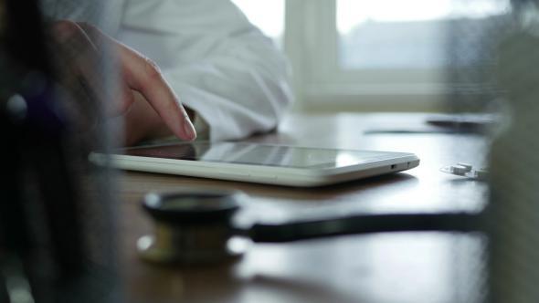 Doctor Typing On Tablet alt