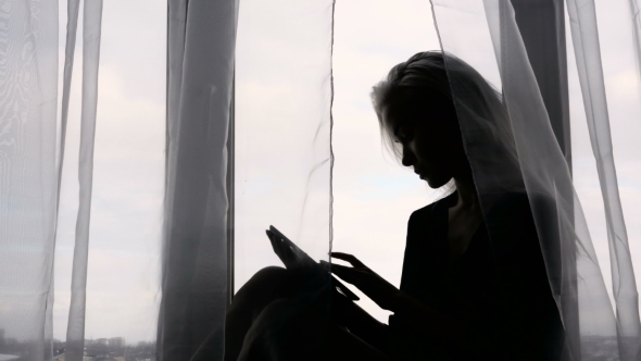 Sensual Silhouette Portrait Of a Young Woman With Tablet