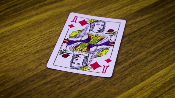 Playing Card Rotates On a Wooden Table