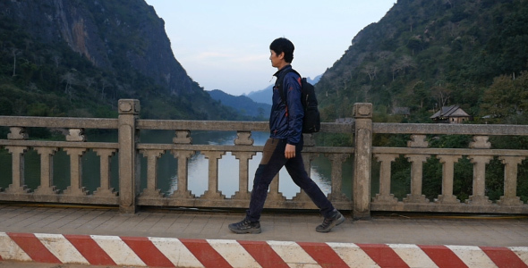 Asian Man Walking On Bridge