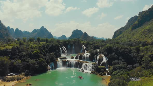 Boats floating near waterfall