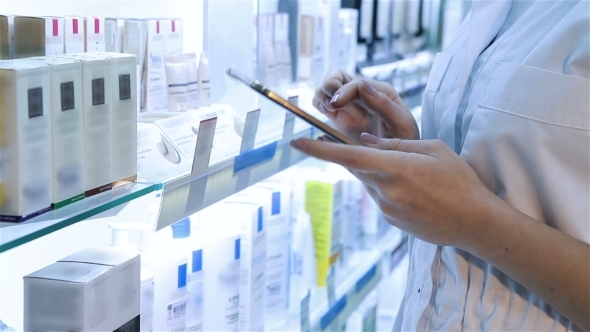 Hands With The Tablet On The Background Of Pharmacy
