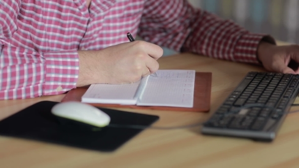 Man Sitting At The Computer And Write In The Diary