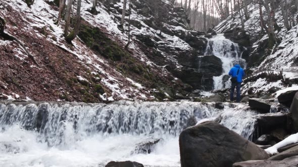 Photographer Making Photo of Winter Waterfalls in