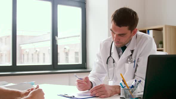 Doctor Writing Prescription for Patient at Clinic 52