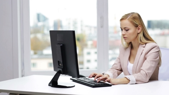 Young Businesswoman With Computer Typing At Office