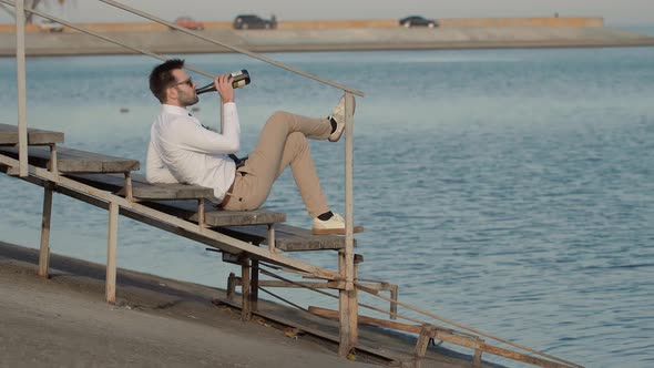 Successful Man Drink Champagne And Relaxing Near River. Businessman Relaxing And Drinking Wine.