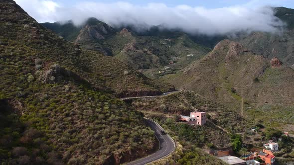 Winding mountain roads and majestic valley of Tenerife island, aerial descend view