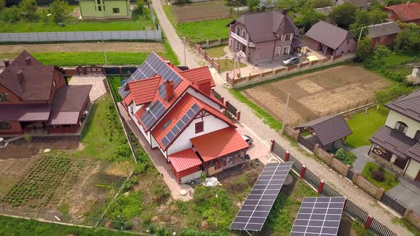 Aerial view of a house in residential area with solar panels on the roof.