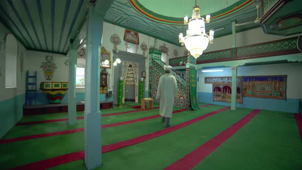 Muslim Mosque Teacher is reading the Quran in Small Historic Wooden Masjid