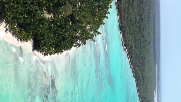 Tropical Island with Coconut Palm Trees and Turquoise Caribbean Sea with Floating Boats