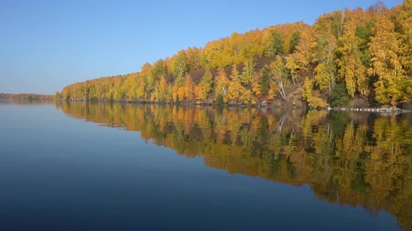 Sail on a Quiet Lake on a Pleasure Boat on a Sunny Autumn Day. Beautiful Reflection of Yellow Trees