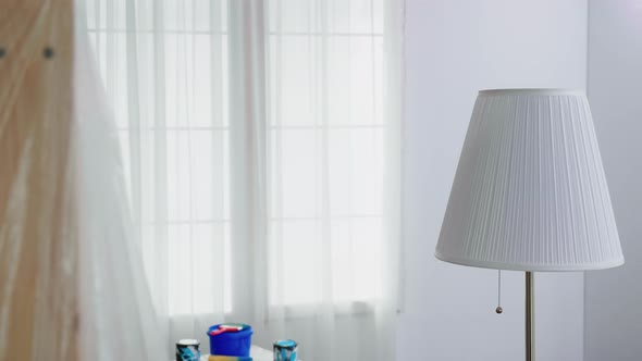 Man Covering Lamp with Plastic Sheet