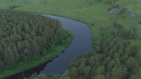 Aerial View of the River with a Rock and Forest on the Banks