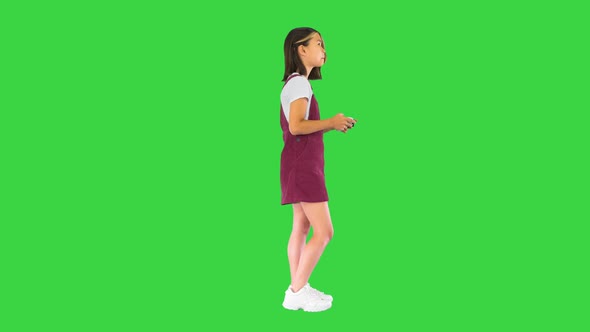 Little Girl Gamer Playing Video Game on a Green Screen Chroma Key