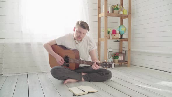 A Man with a Guitar Composing a Song