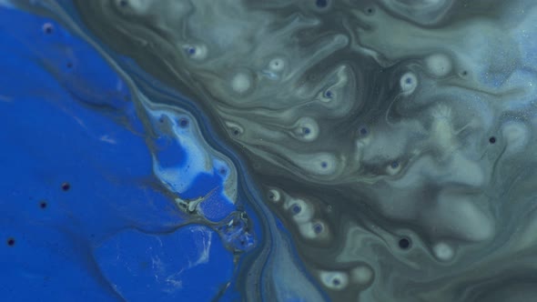 Blue, black, silver colors oil paint pouring close up. Fluid Art painting. Paint movement macro