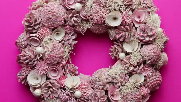 Christmas Wreath Made with Flowers, Pines and Leafs Isolated on Pink Background