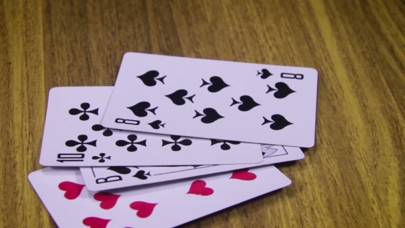 Playing Cards Rotates On a Wooden Table
