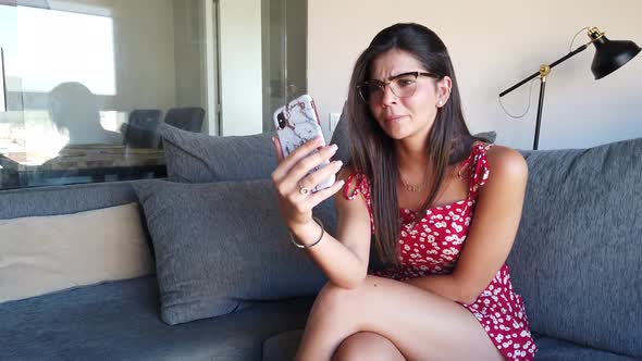 Smiling woman doing video call on smartphone at home