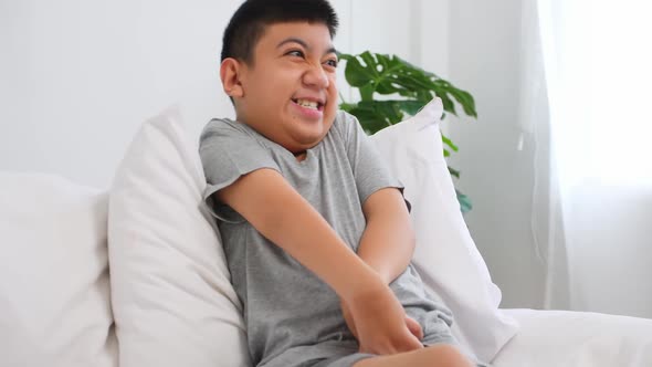 Disabled boy sitting on sofa at home.