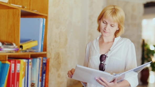 Tourist Reads An Information Booklet Stand Near The Hotel