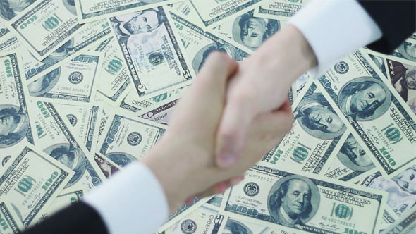 Business Handshake on the Background of Dollars