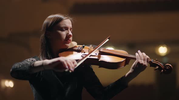 Inspired Female Violinist is Playing Melody in Symphonic Orchestra Portrait of Fiddler on Scene