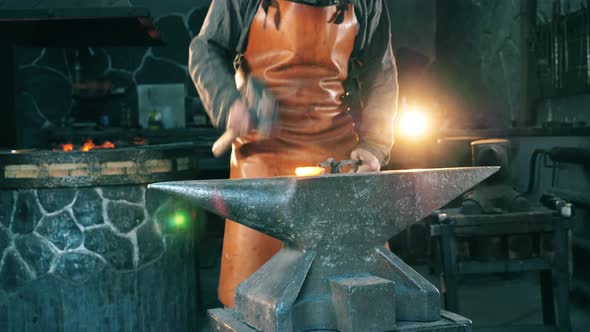 One Man Works with Knife on Anvil at a Forge