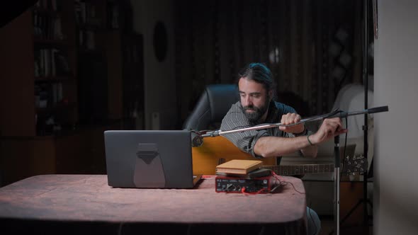 Young Attractive Songwriter Adjusting His Tripod Before Performing in an Online Concert